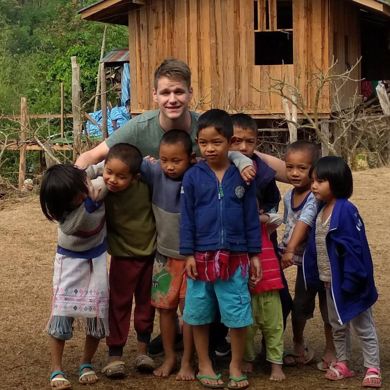 Dennis with children in a mountain village